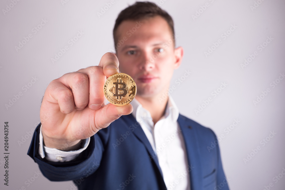 Golden Bitcoin in a man hand, Digitall symbol of a new virtual currency Golden Bitcoin in a man hand, Digitall symbol of a new virtual currency