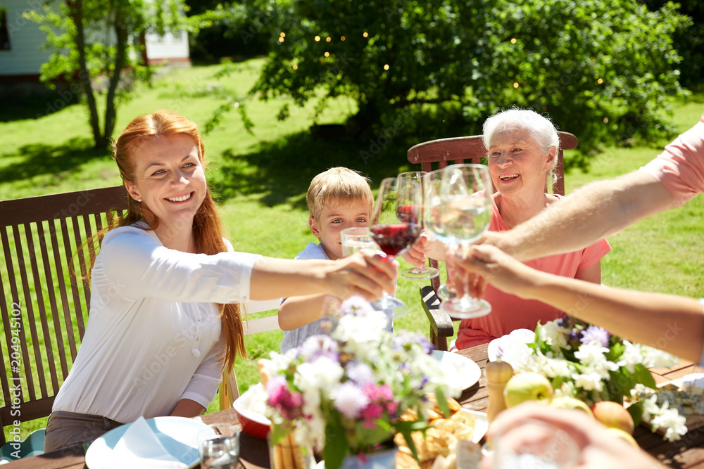 leisure, holidays and people concept - happy family having festive dinner or summer garden party and celebrating