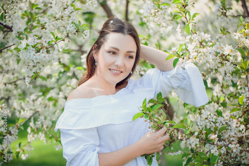 Young beautiful blonde woman in blooming almonds garden. Young beautiful blonde woman in blooming almonds garden.