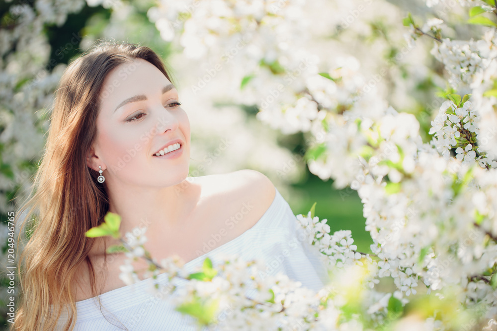 Young beautiful blonde woman in blooming almonds garden. Young beautiful blonde woman in blooming almonds garden.