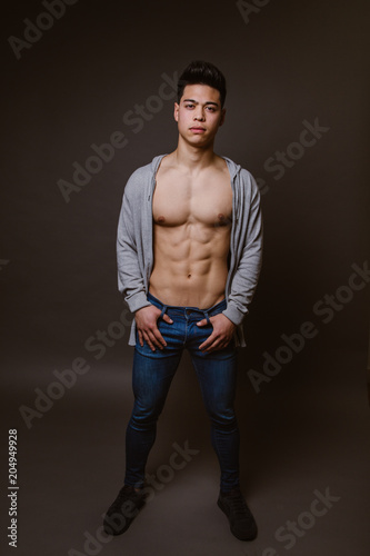 Fit male model posing on dark background photo