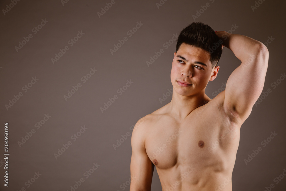 Muscular man posing on dark background Muscular man posing on dark background