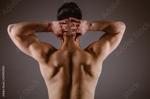 Man muscular back on dark background