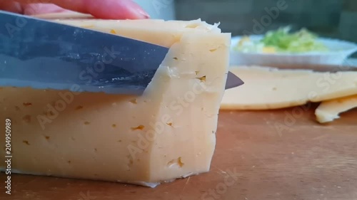 knife slicks cheese on wooden photo