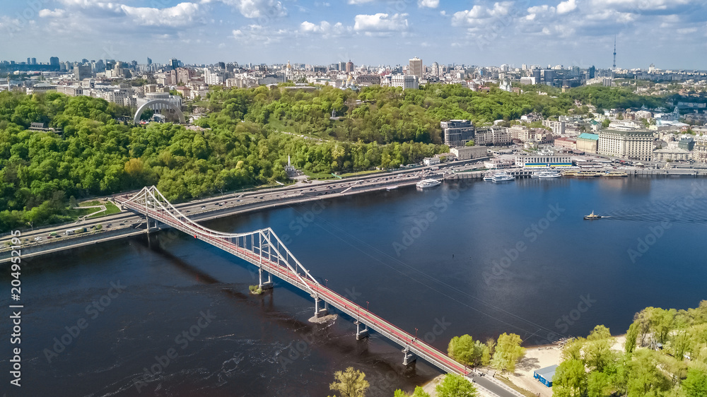 Aerial top view of pedestrian Park bridge, Dnieper river and Kyiv hills from above, city of Kiev, Ukraine
