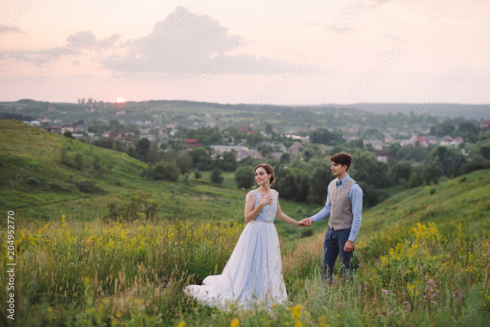 Romantic and happy caucasian couple in stylish clothes hugging on the background of beautiful nature. Love, relationships, romance, happiness concept. Man and woman walking outdoors together. Romantic and happy caucasian couple in stylish clothes hugging on the background of beautiful nature. Love, relationships, romance, happiness concept. Man and woman walking outdoors together.