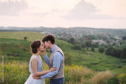 Romantic and happy caucasian couple in stylish clothes hugging on the background of beautiful nature. Love  relationships  romance  happiness concept. Man and woman walking outdoors together.