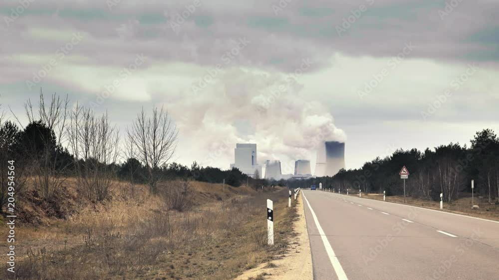 Cooling system of nuclear power plant, huge clouds and smoke in background. Cooling towers of power station. Concrete thermal power plant towers. Industrial architecture. 4k resolution footage