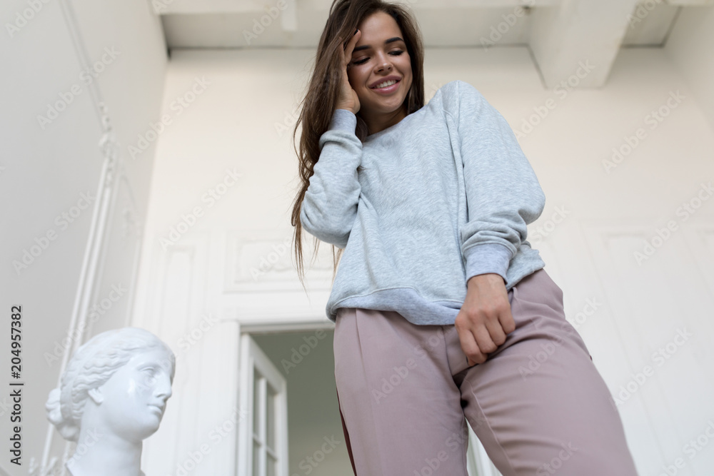 Smiling young woman in a gray sweatshirt. Mock-up.