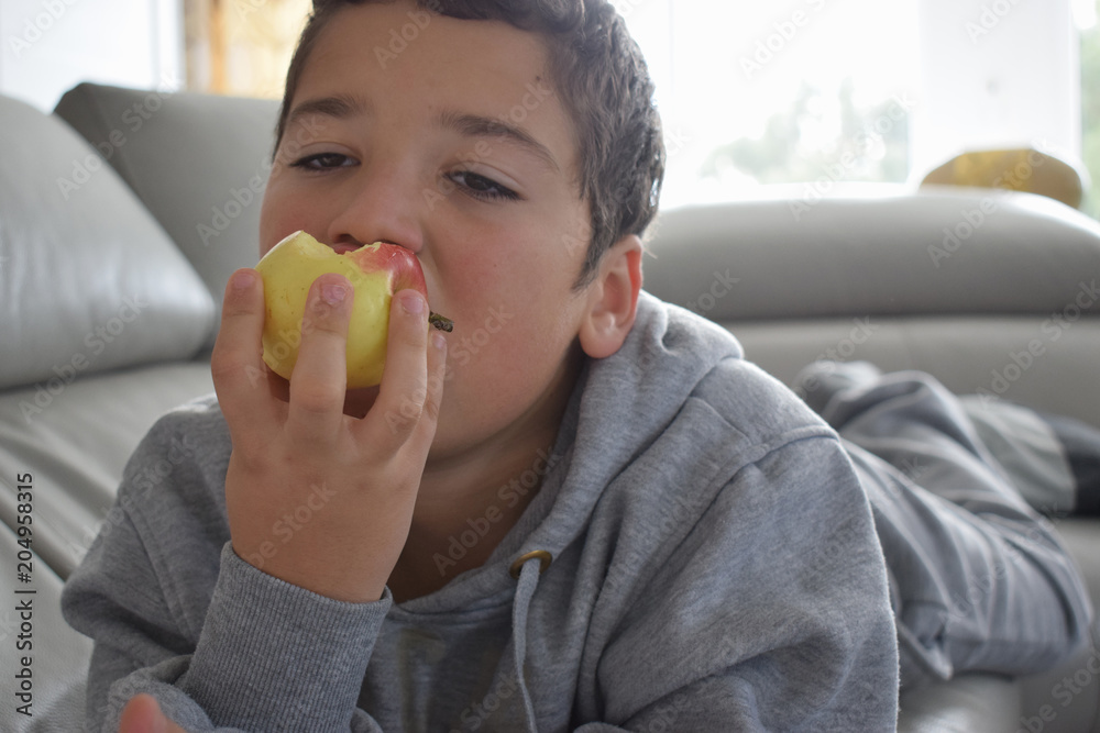 chico guapo con brillantes ojos marrones comiendo una manzana chico guapo con brillantes ojos marrones comiendo una manzana