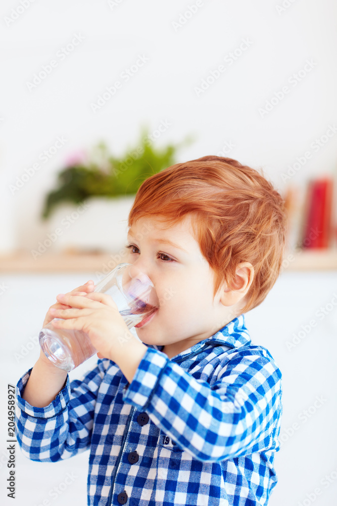 cute toddler baby boy drinking fresh water from glass early in the morning in pajamas cute toddler baby boy drinking fresh water from glass early in the morning in pajamas