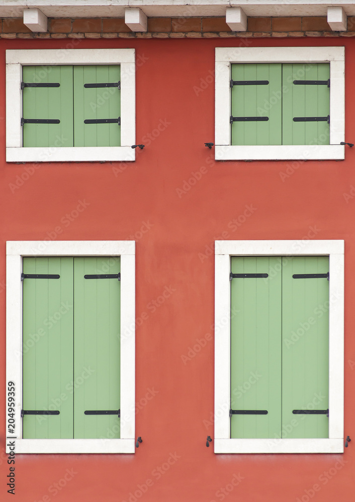 closeup of a particular facade of a building with green windows