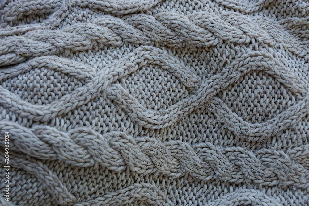 Gray woolen texture of a sweater fabric with a pattern Gray woolen texture of a sweater fabric with a pattern