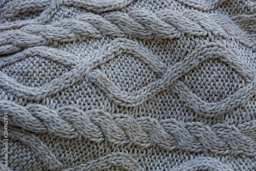 Gray woolen texture of a sweater fabric with a pattern