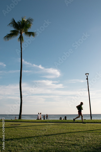 Un hombre corre frente al mar en Waikiki, Hawaii