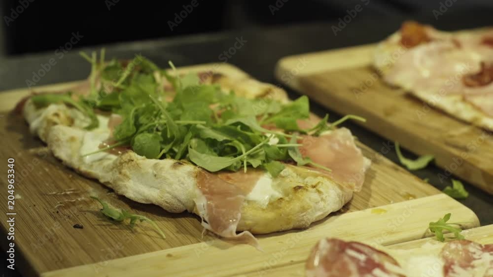 Close up, chef adds leafy greens to pizza Close up, chef adds leafy greens to pizza