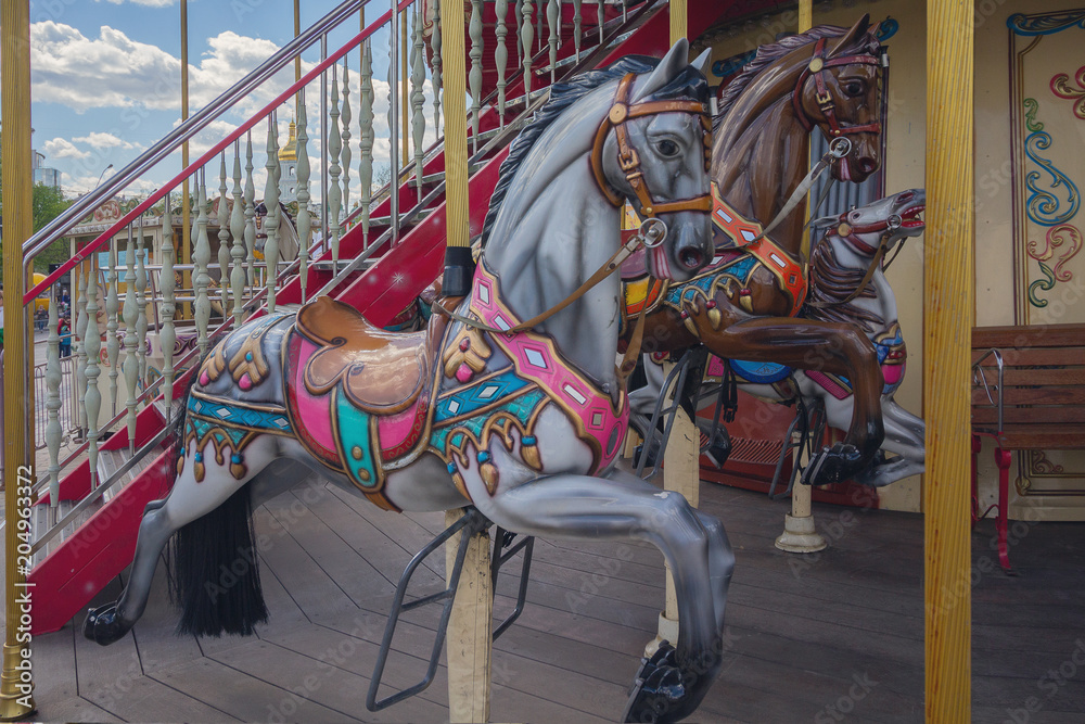 Horses on ac vintage carousel a holiday park.