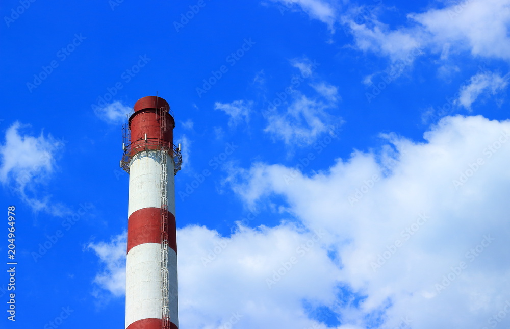 Industrial landscape with boiler pipe with red and white stripes against on a blue sky with clouds background with copy space. Industrial landscape with boiler pipe with red and white stripes against on a blue sky with clouds background with copy space.