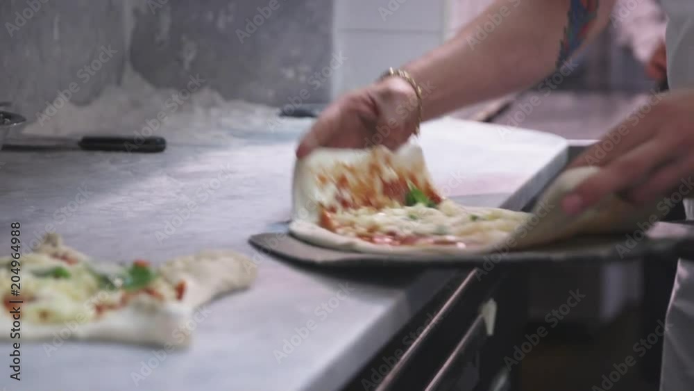 Chef puts pizza into wood stove Chef puts pizza into wood stove
