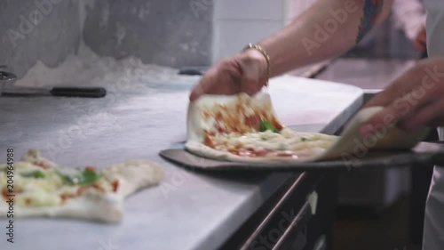 Chef puts pizza into wood stove