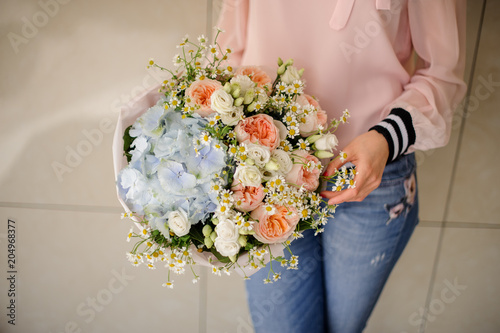 Girl holding a beautiful bouquet of blue and rose colour tender flowers photo