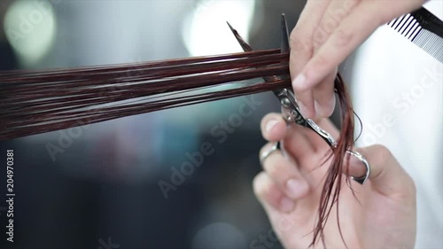 Close up, stylist trims hair in slow motion