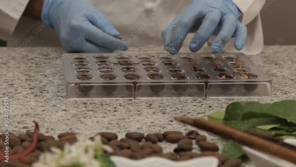 Chef adds various nuts to chocolate, tilt up