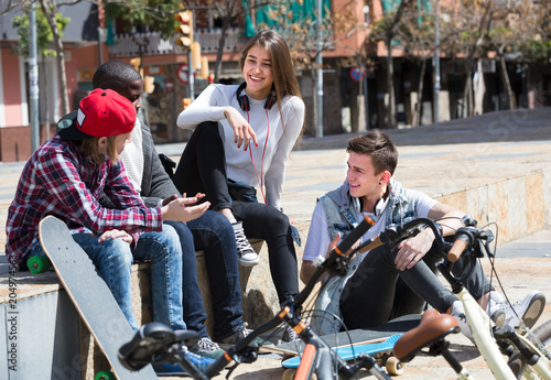 teens chatting near bikes