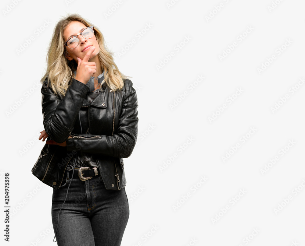 Young student woman with headphones thinking and looking up expressing doubt and wonder Young student woman with headphones thinking and looking up expressing doubt and wonder