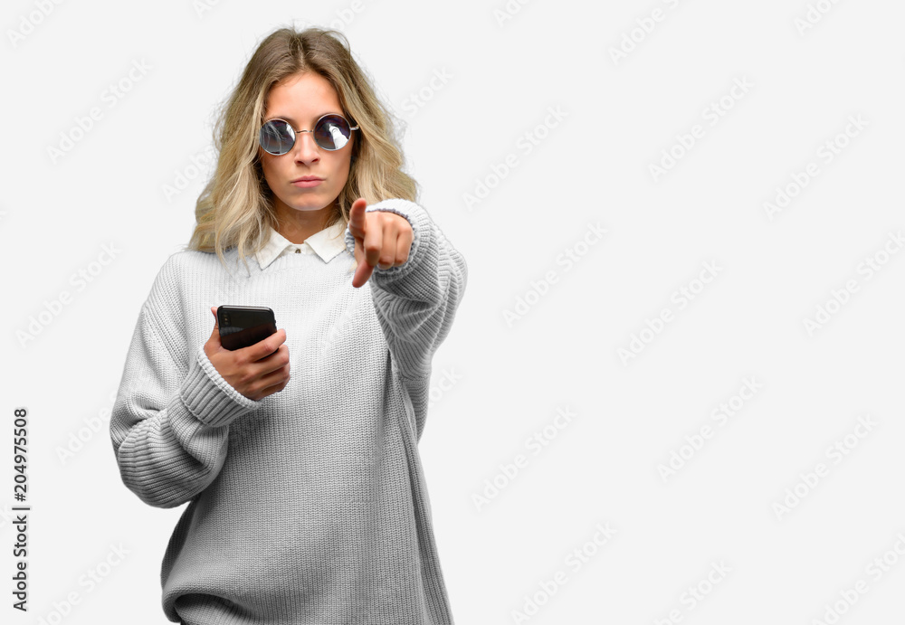 Young beautiful woman using smartphone pointing to the front with finger Young beautiful woman using smartphone pointing to the front with finger