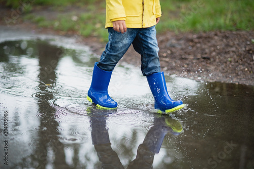 Little boy playing in puddle