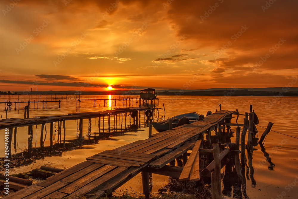 Stunning sunset at the seashore with wooden pier