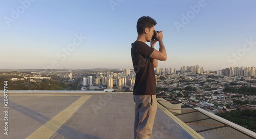 Photography Photographer taking photos on top of the building at sunset