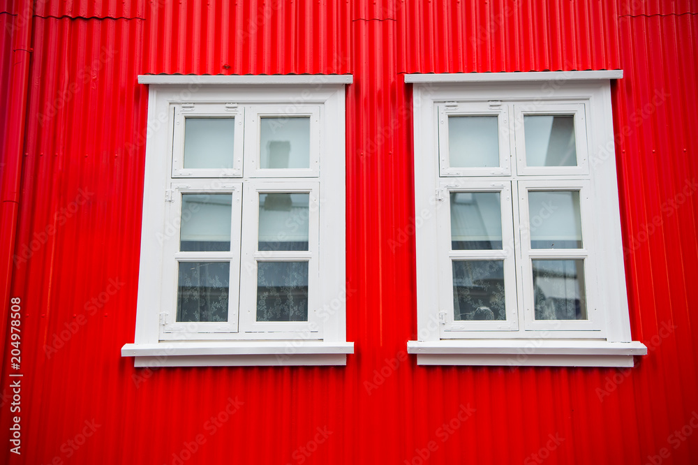 Windows in house in reykjavik, iceland. Building facade with red wall and white window frames. Architecture structure and design Windows in house in reykjavik, iceland. Building facade with red wall and white window frames. Architecture structure and design