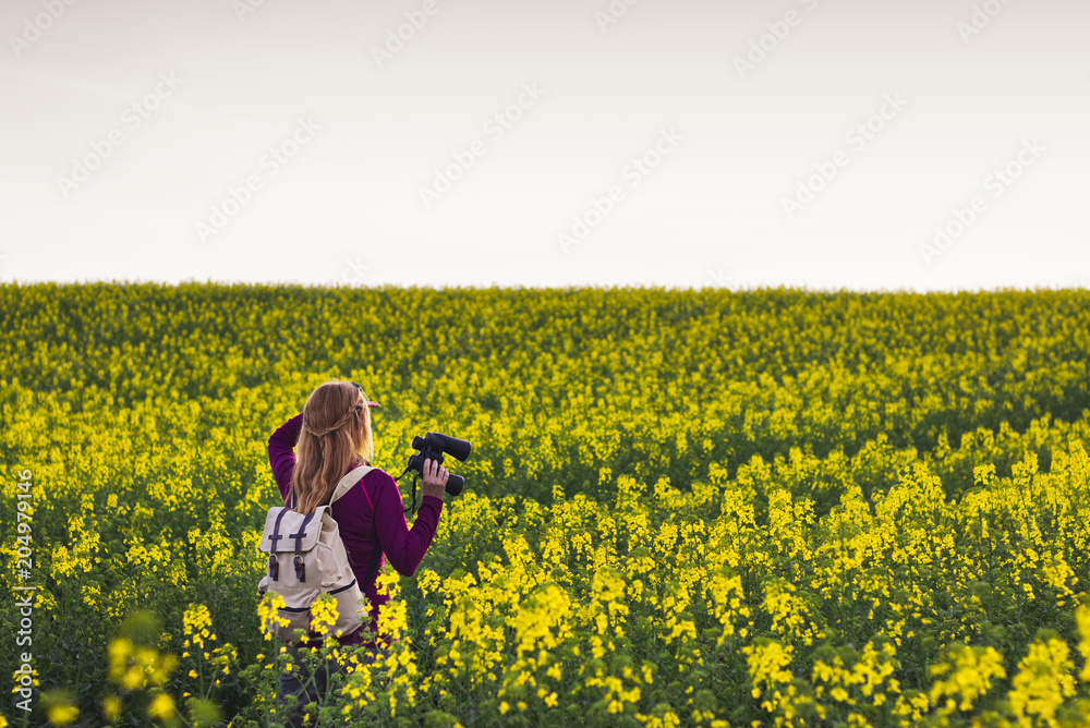 Hiking woman watching landscape with binoculars 