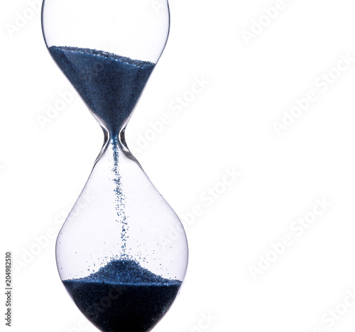 Hourglass dropping sand, running time, isolated on a white background, macro closeup with blue sand and lots of detail