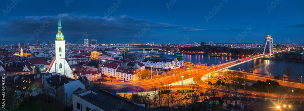 Cityscape of Bratislava, Slovakia with St. Martin's Cathedral and Danube River with New Bridge at Night