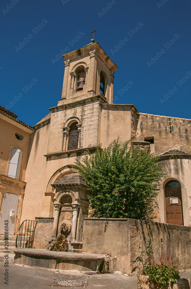 Close-up of church with steeple and flowers, in the historical village of Lourmarin. Located in the Vaucluse department, Provence-Alpes-Côte d'Azur region, southeastern France