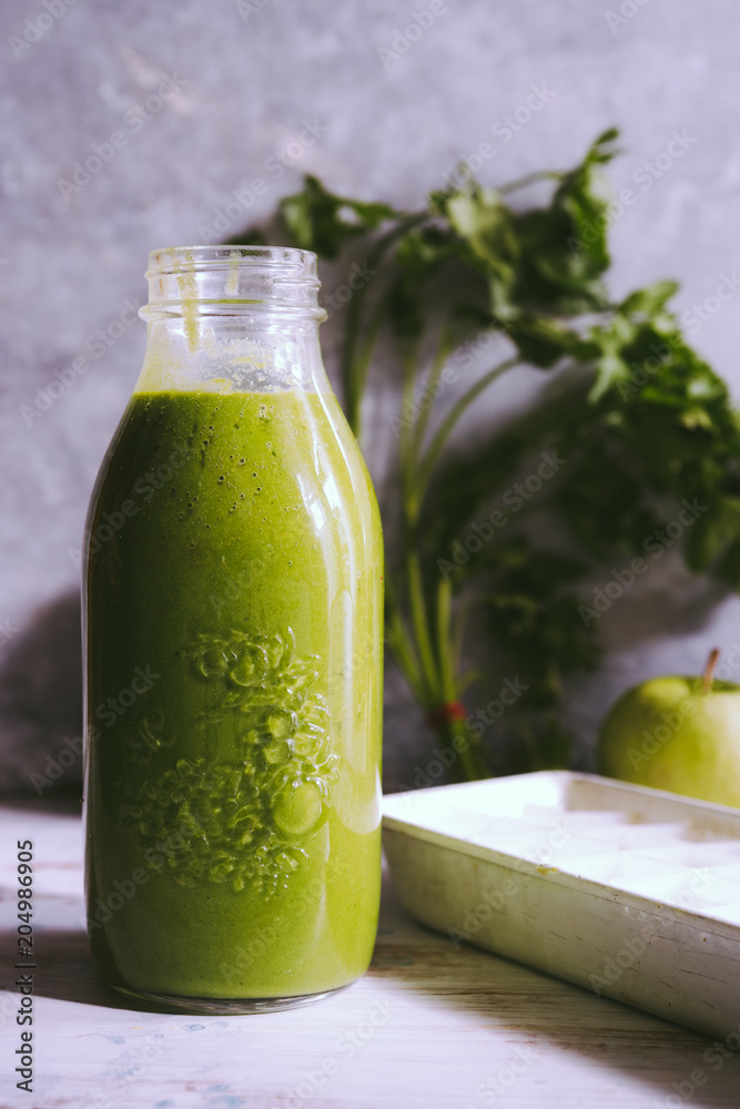 Healthy green smoothie with kale banana and date in glass bottles against a dark background. Detox, diet, healthy, vegetarian food concept with copy space. Healthy green smoothie with kale banana and date in glass bottles against a dark background. Detox, diet, healthy, vegetarian food concept with copy space.