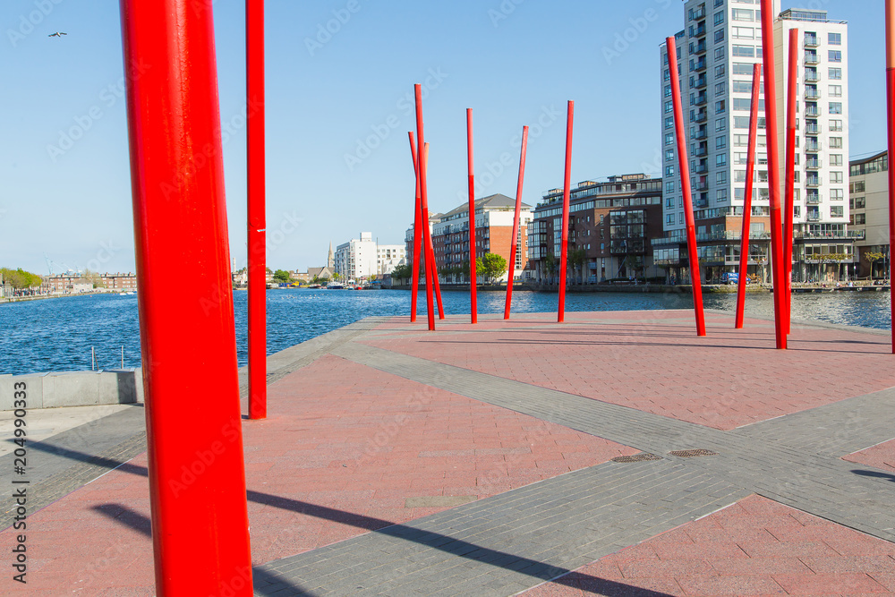 Fototapeta premium A view of Grand Canal Square in Dublin's regenerated Docklands with red columns standing randomly.