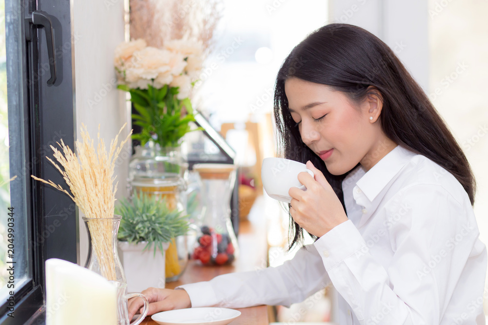 Beautiful young asian woman drinking coffee and smile in the morning at cafe, girl sitting in coffee shop for breakfast and leisure during free time. Beautiful young asian woman drinking coffee and smile in the morning at cafe, girl sitting in coffee shop for breakfast and leisure during free time.