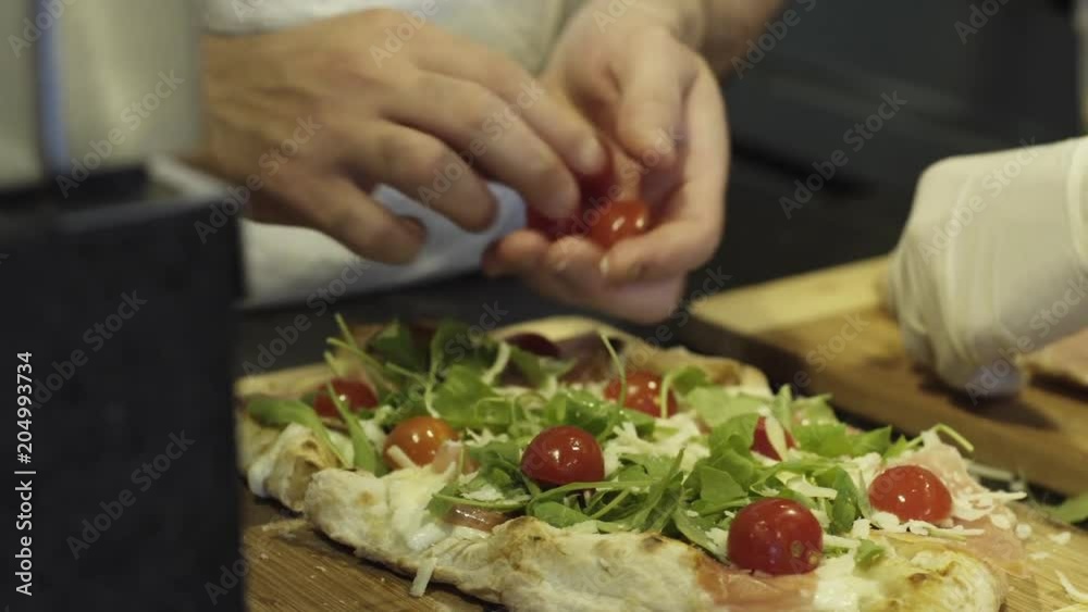 Close up, chef adds vegetables to pizza Close up, chef adds vegetables to pizza