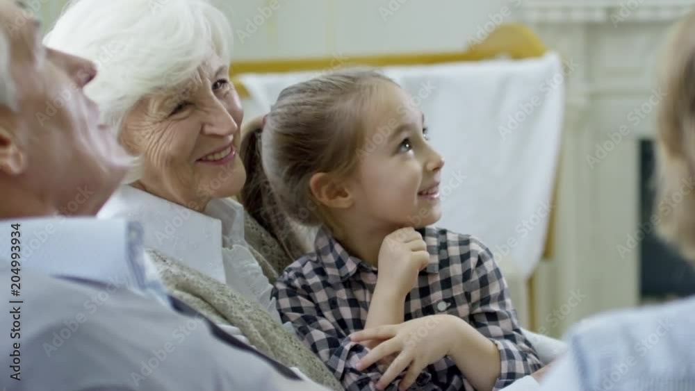 Medium shot with side view of cute girl and unrecognizable boy chatting with grandparents Medium shot with side view of cute girl and unrecognizable boy chatting with grandparents