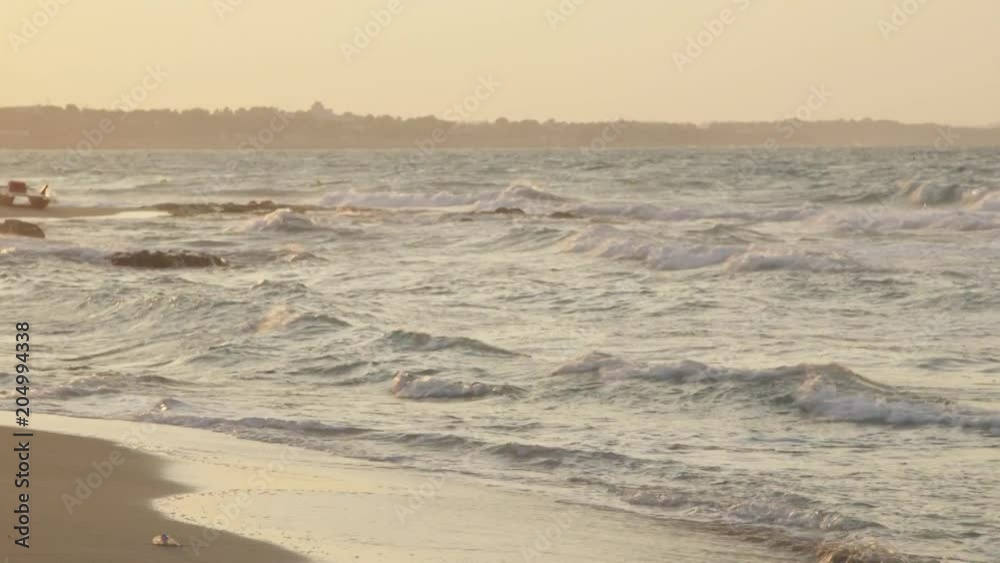 Wide, waves lap on shore at sunset Wide, waves lap on shore at sunset