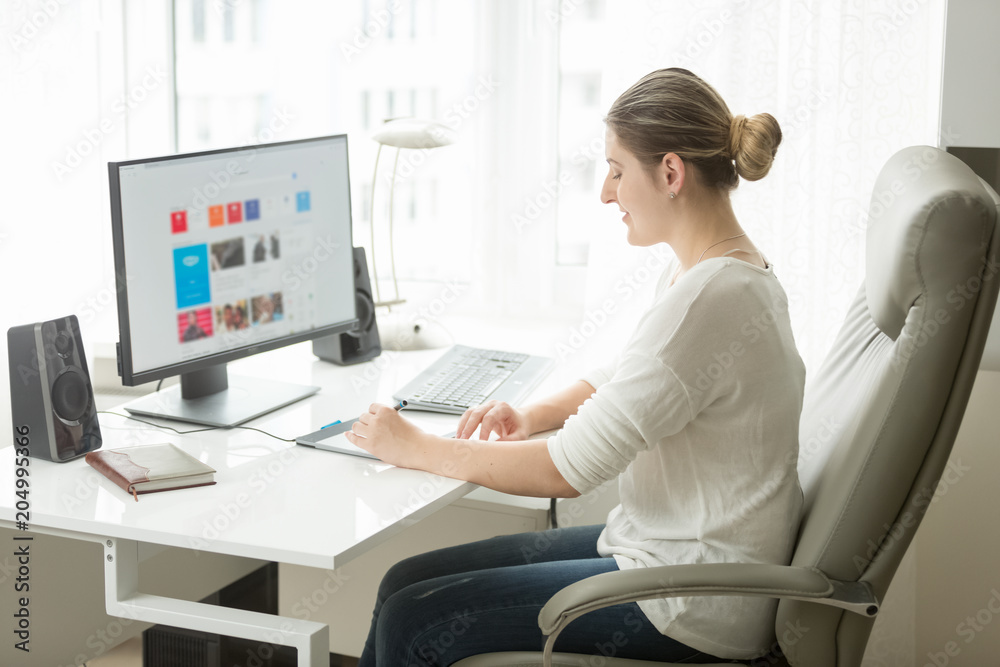 Beautiful young woman working on computer at home office Beautiful young woman working on computer at home office