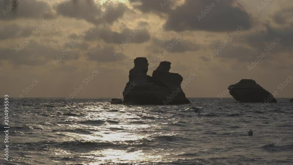 Wide, sunset over rock formation in ocean Wide, sunset over rock formation in ocean