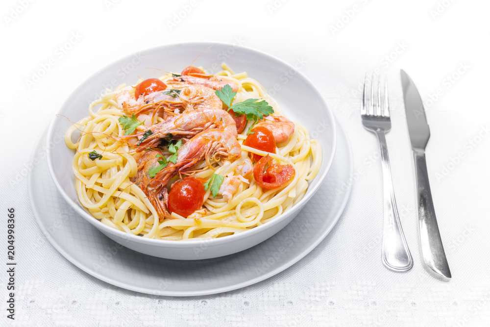 Linguine with shrimps and cherry tomatoes. The shrimps of the Mediterranean are precious crustaceans, the sauce is also accompanied by pepper and fresh parsley