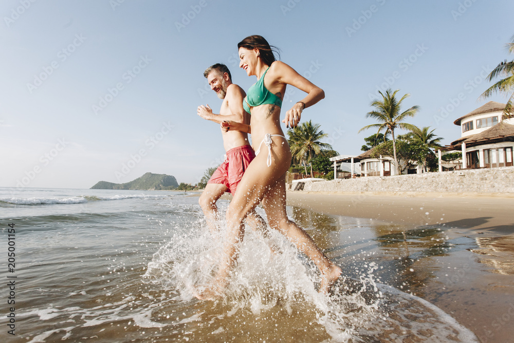 Fototapeta premium Happy couple running into the water