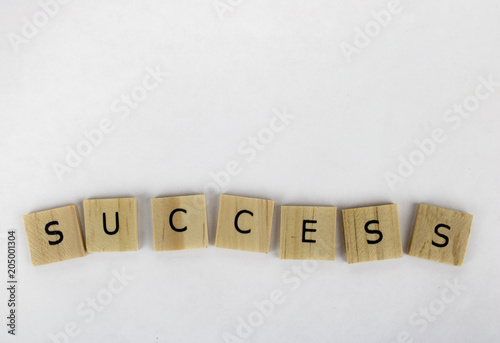 Wooden tiles spelling out the word success on an isolated white background. Inspirational and motivational! Room for text! 