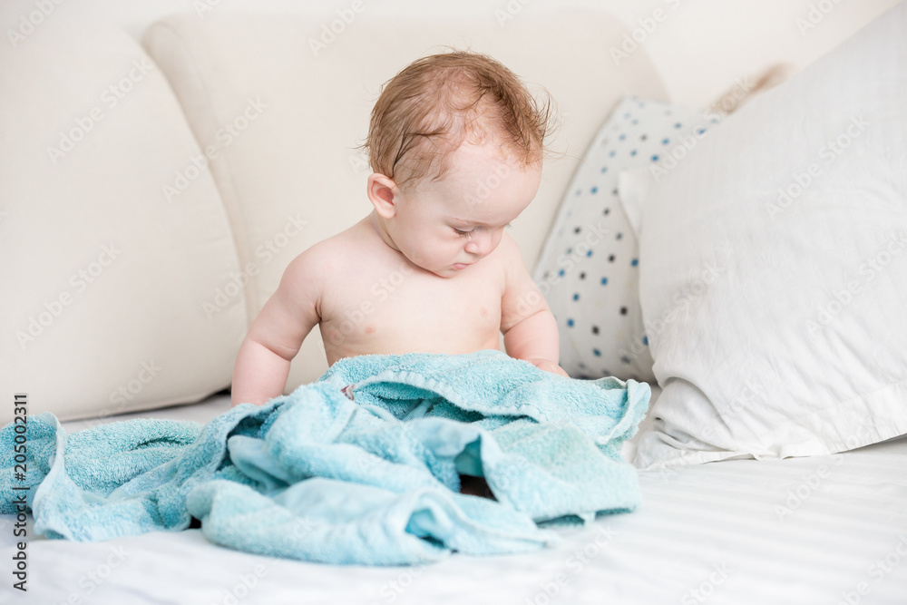Cute baby boy sitting on towel after having bath Cute baby boy sitting on towel after having bath